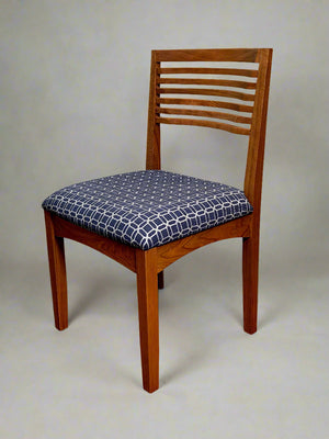 Wooden chair with a patterned cushion on a plain background