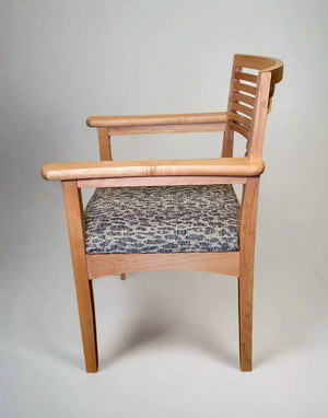 Wooden chair with a patterned cushion on a plain background